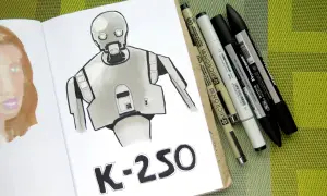 Rysunki markerami przedstawiają robota K-2SO i fragment twarzy. Obok leżą różnorodne pisaki.