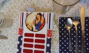 Jak zrobić zdrapkę w stylu pin-up? Na stole leży karta z wizerunkiem kobiety, pod nią rzędy czerwonych pól do zdrapania.