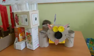 Zabawny robot z recyklingu, zrobiony z pudełek po herbacie i rolki po papierze toaletowym. Idealny przykład, jak zrobić robota z recyklingu.