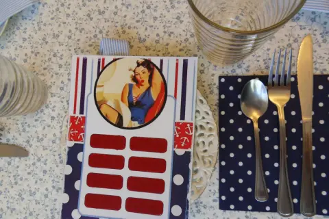 Jak zrobić zdrapkę w stylu pin-up? Na stole leży karta z wizerunkiem kobiety, pod nią rzędy czerwonych pól do zdrapania.