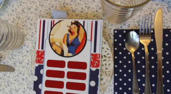 Jak zrobić zdrapkę w stylu pin-up? Na stole leży karta z wizerunkiem kobiety, pod nią rzędy czerwonych pól do zdrapania.