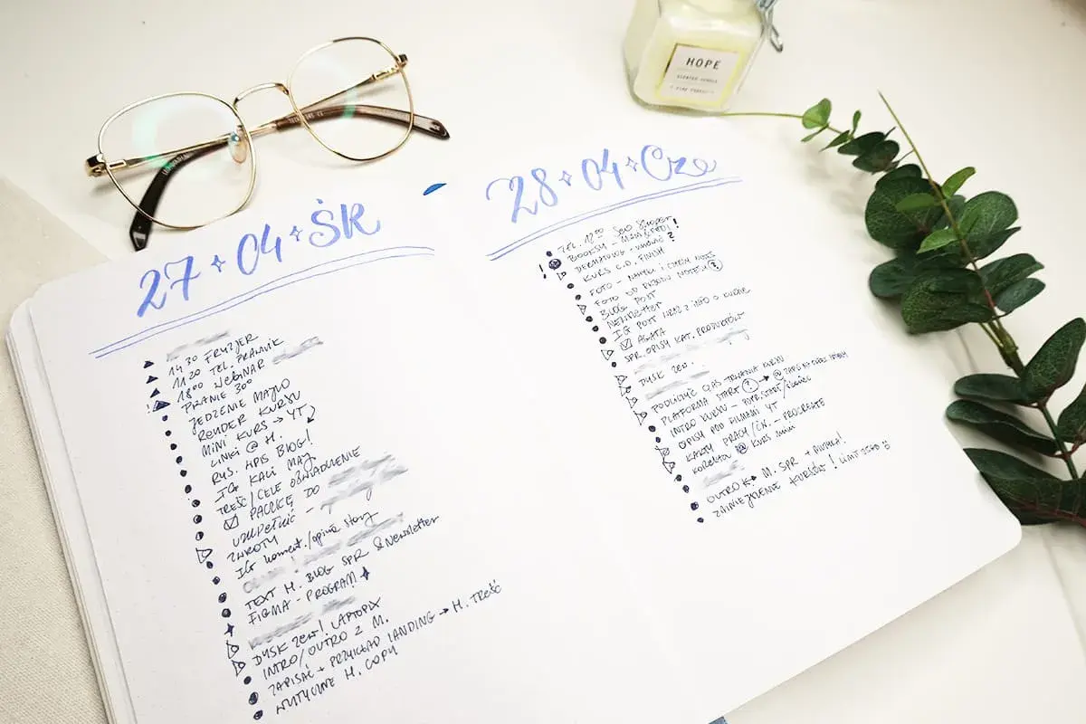 Bullet journal pomysły na każdy dzień. Lista zadań i notatek w dzienniku, obok okulary i świeca.