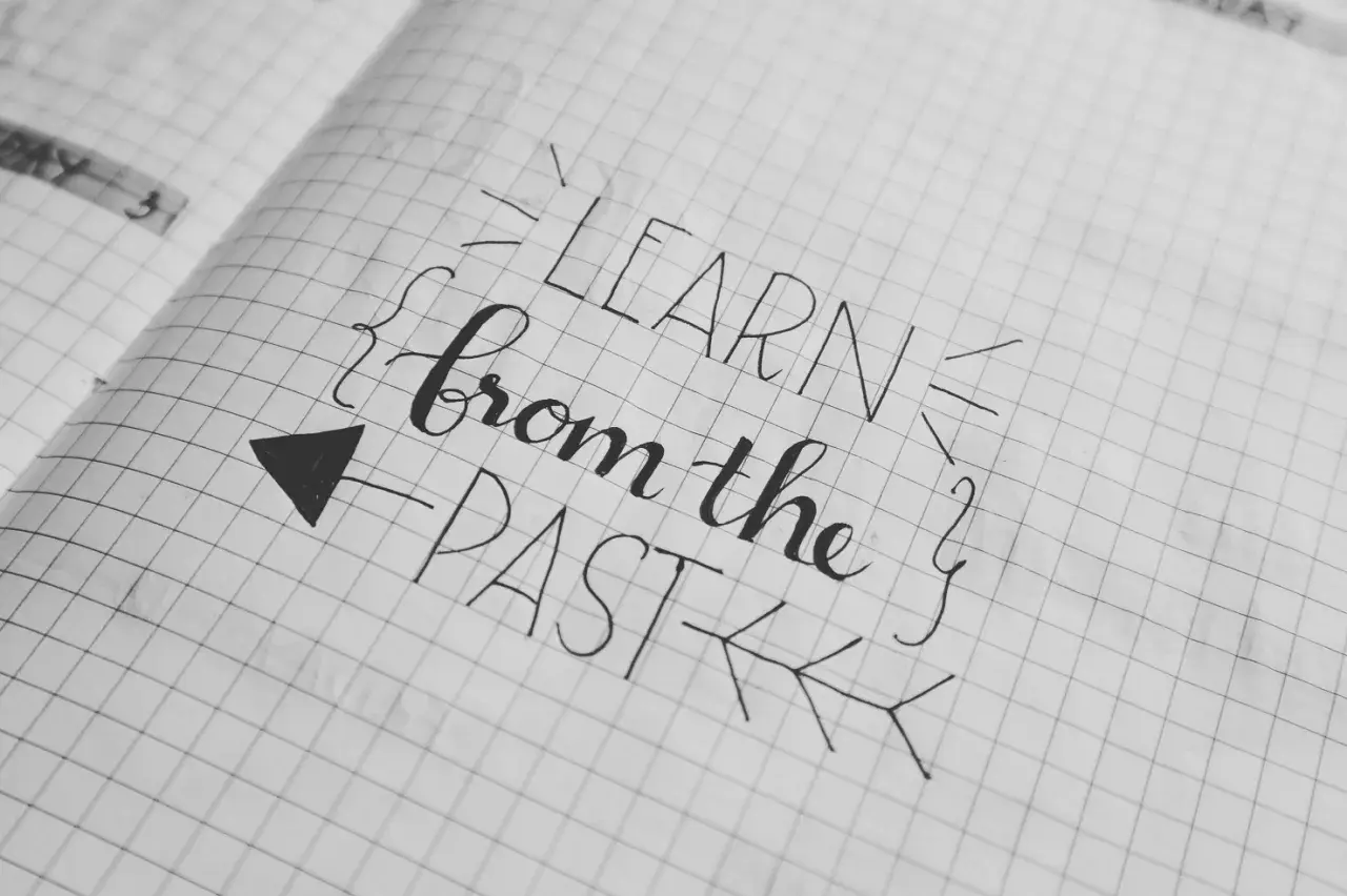 Piękna zmiana pisma w zeszycie: "LEARN from the PAST". Strzałka wskazuje kierunek nauki.